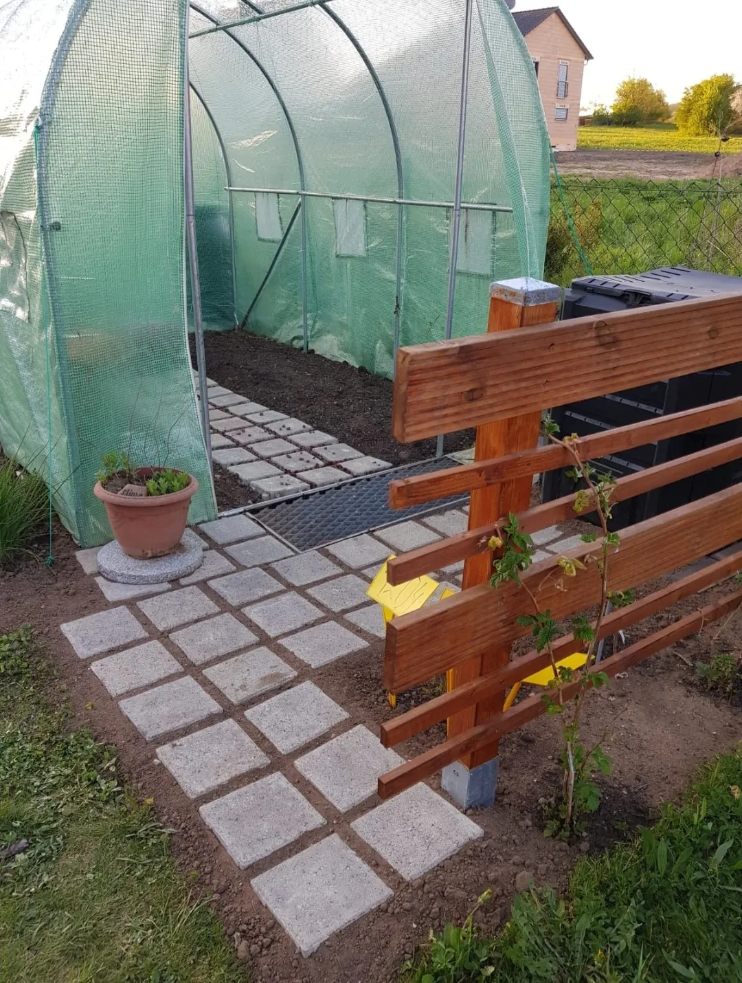 Die Gartenfee, Gartenfliesen, eine Bank und ein Blumentopf